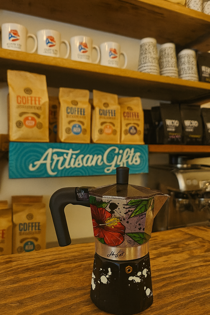 Colorful Puerto Rican coffee maker displayed on a wooden table with coffee bags in the background