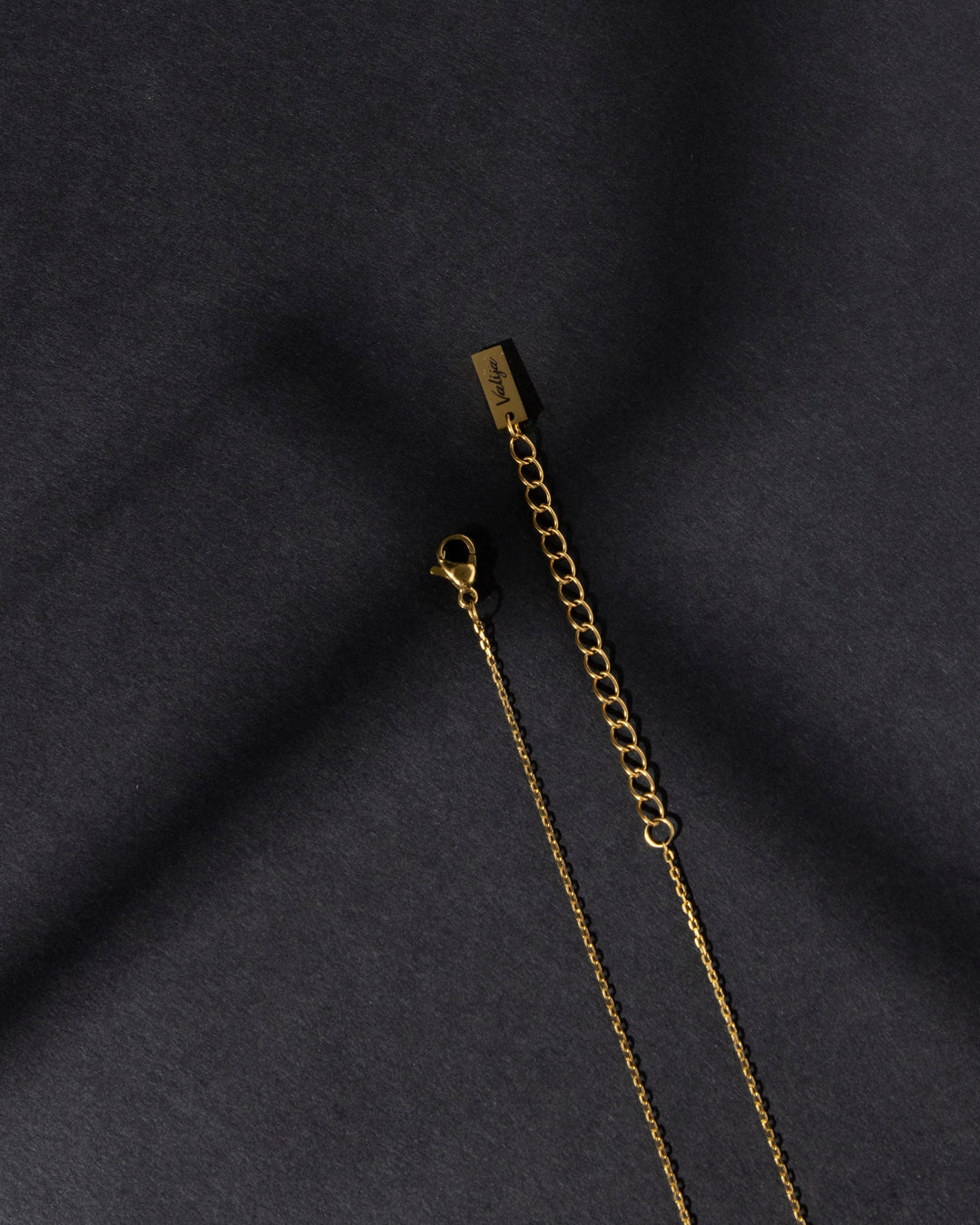 Close-up of Valija Ay Bendito necklace with gold chain and lobster clasp detail