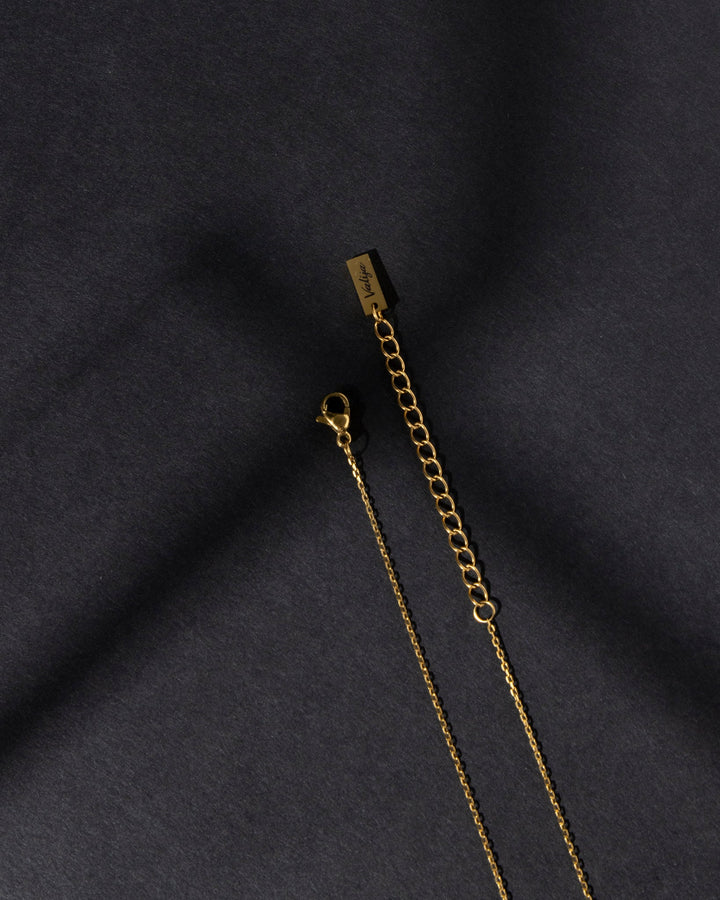Close-up of Valija Ay Bendito necklace with gold chain and lobster clasp detail