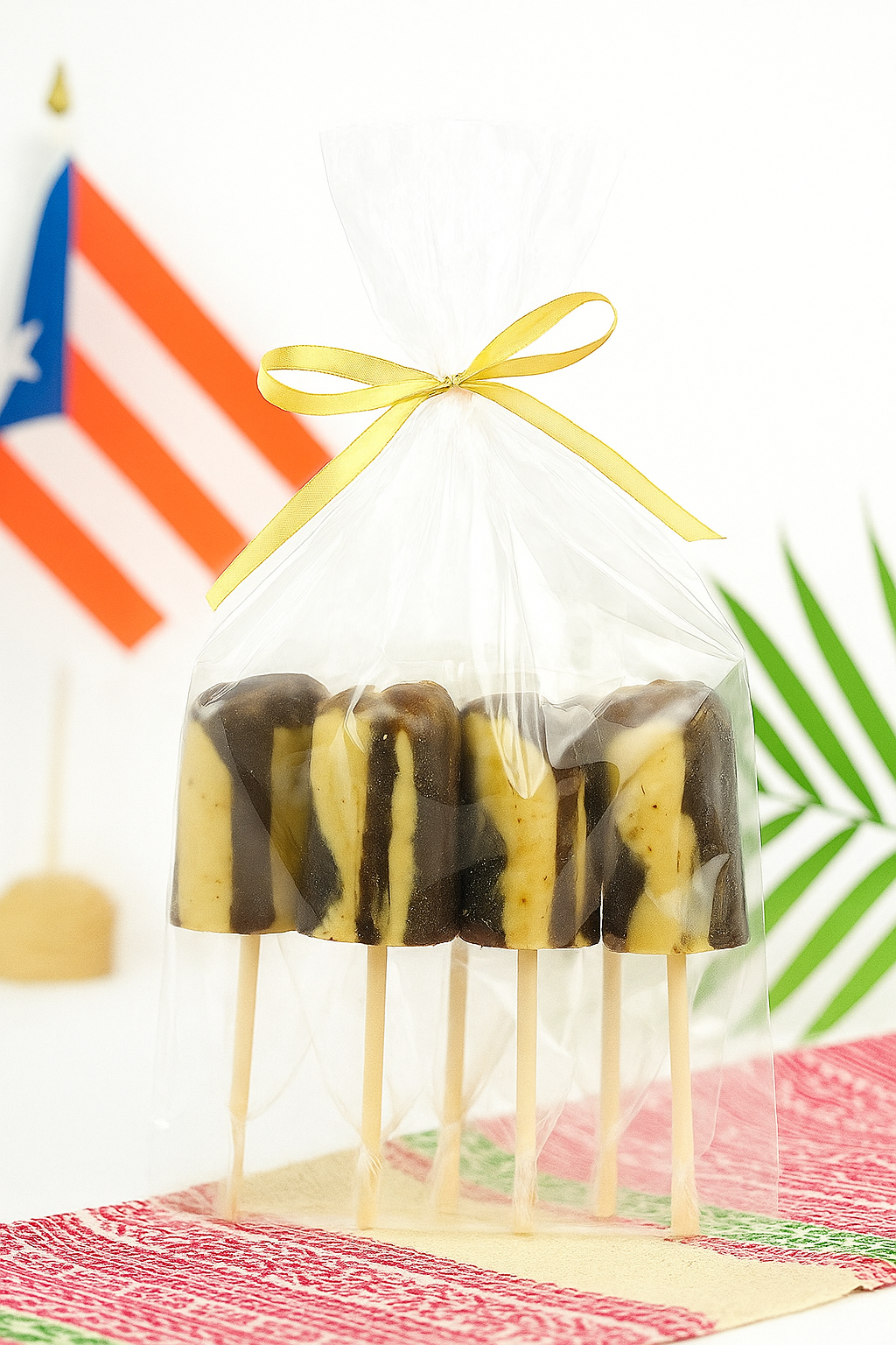 El Artesano Puerto Rican coffee lollipop set wrapped with a gold ribbon and displayed with a Puerto Rican flag
