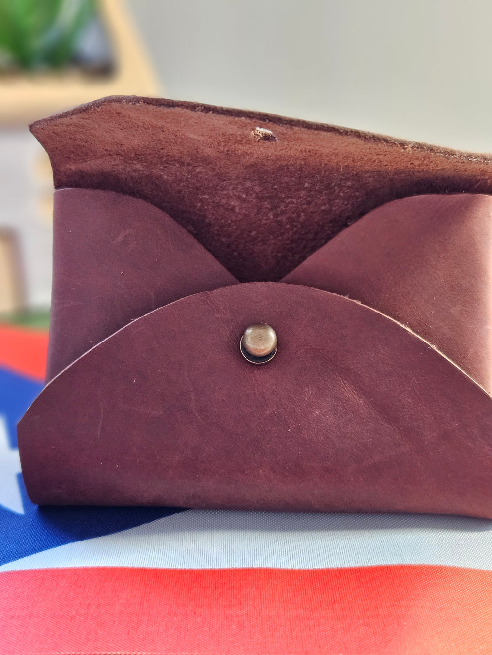 Brown leather pouch gift handcrafted by Atelierry, featuring a stylish fold-over design and snap closure