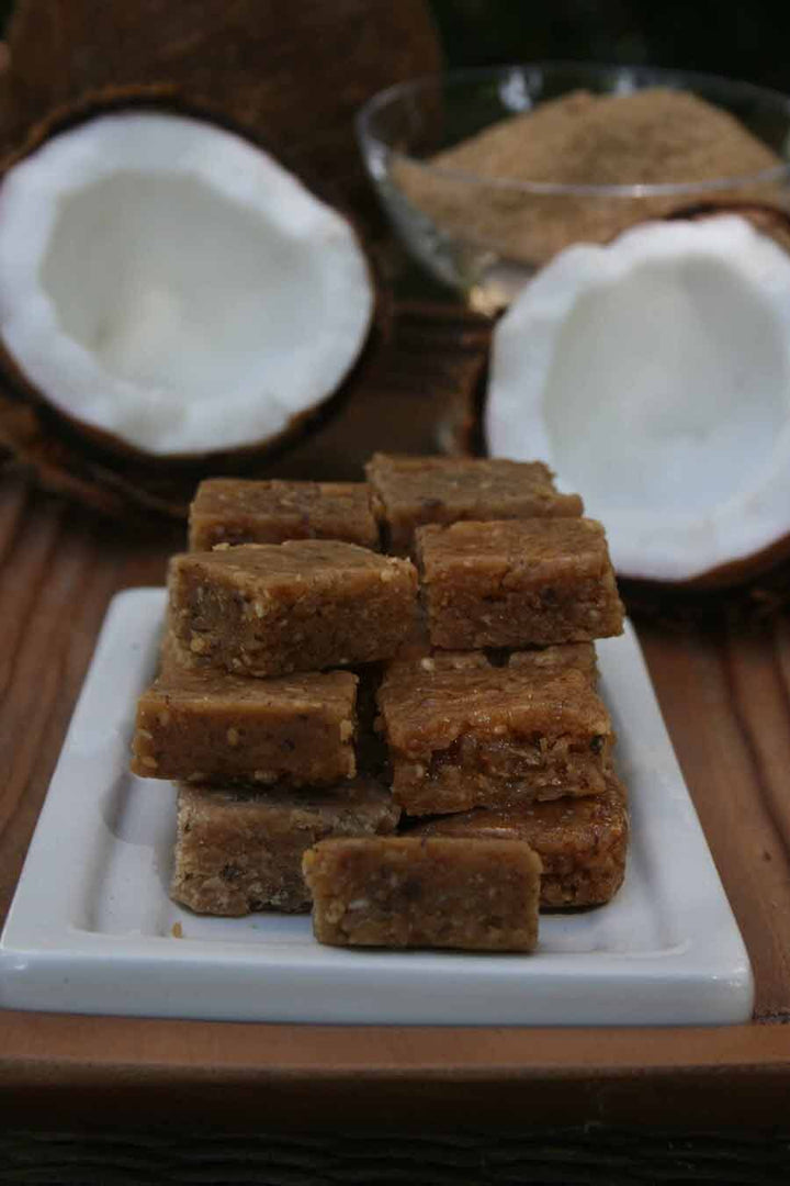 Coconut candy pieces on a plate with fresh coconuts, Puerto Rico treat from Boricua Gift Shop