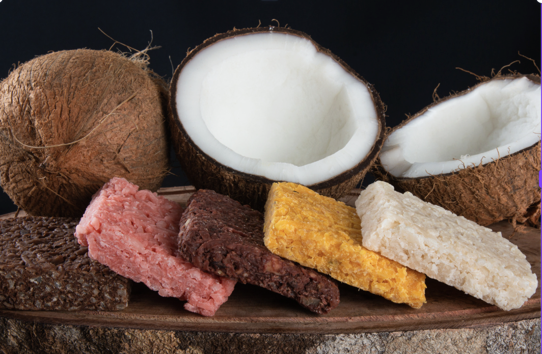 Coconut candy varieties on wooden board with fresh coconuts from Puerto Rico