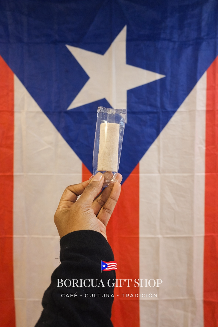 Cremitas de coco artesanal held up in front of a Puerto Rican flag