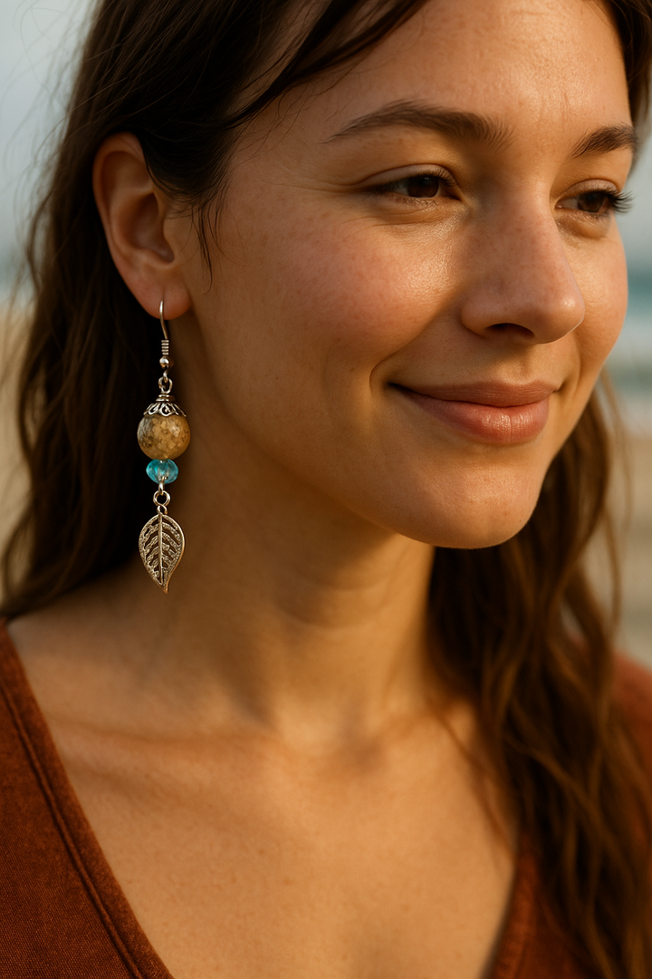Lagunarte sand and crystal earrings with leaf charm worn by smiling woman outdoors