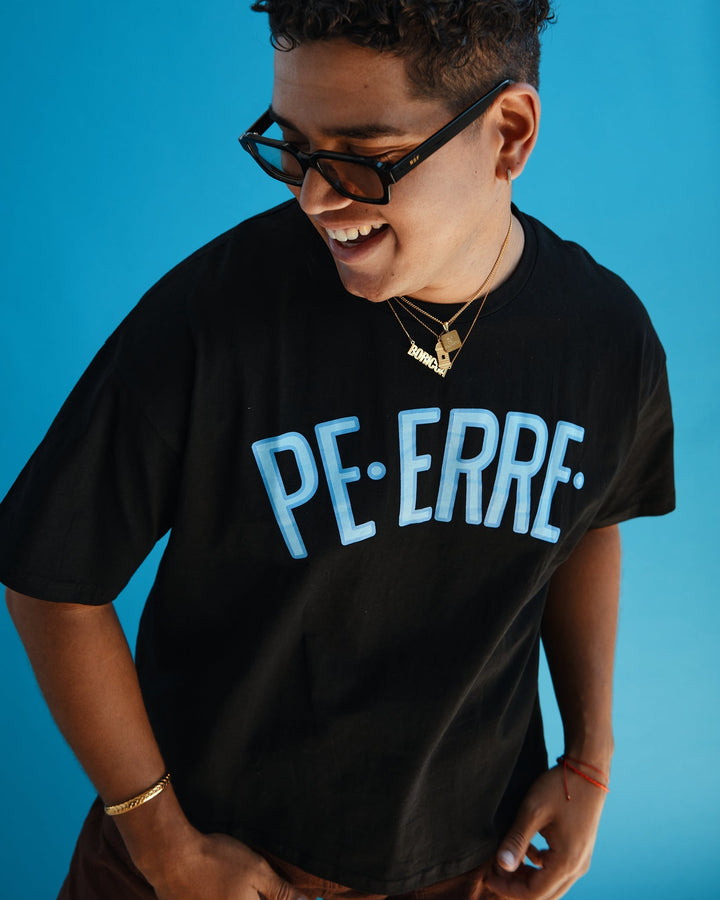 Black Valija PE ERRE t-shirt with bold blue lettering on a model against a blue background