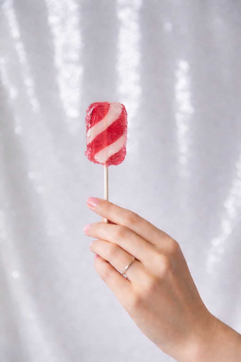 Puerto Rican coconut strawberry candy held on a stick