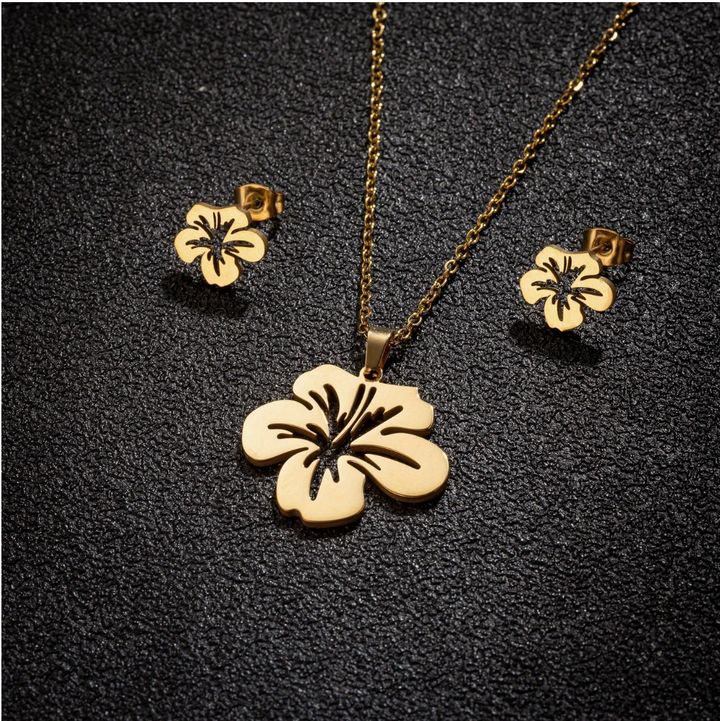 Puerto Rican floral jewelry set featuring a gold hibiscus necklace and matching earrings