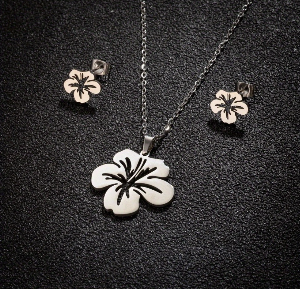 Puerto Rican floral jewelry set featuring a hibiscus pendant and matching earrings in silver and rose gold