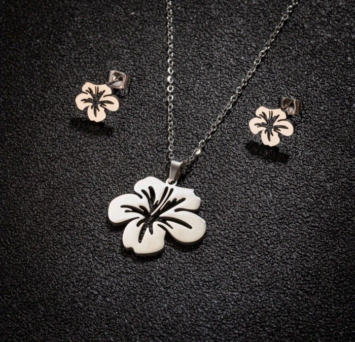 Puerto Rican floral jewelry set featuring a hibiscus pendant and matching earrings in silver and rose gold