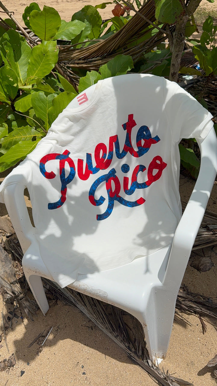 Puerto Rico graphic t-shirt displayed on a beach chair surrounded by tropical foliage