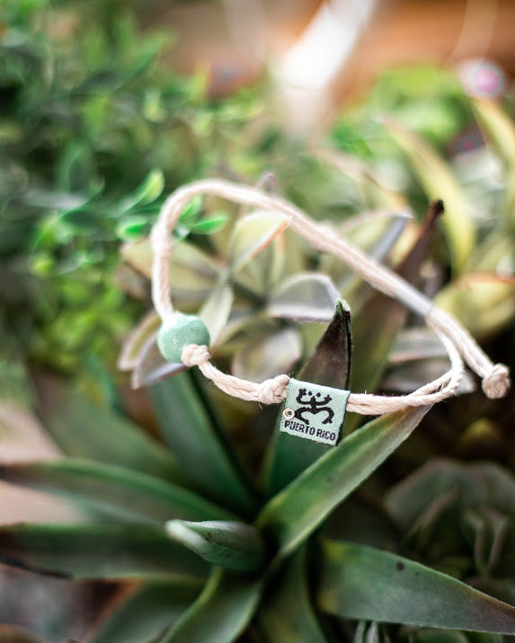 Earth Bands resilience cultural bracelet with natural stone on a braided cord against greenery