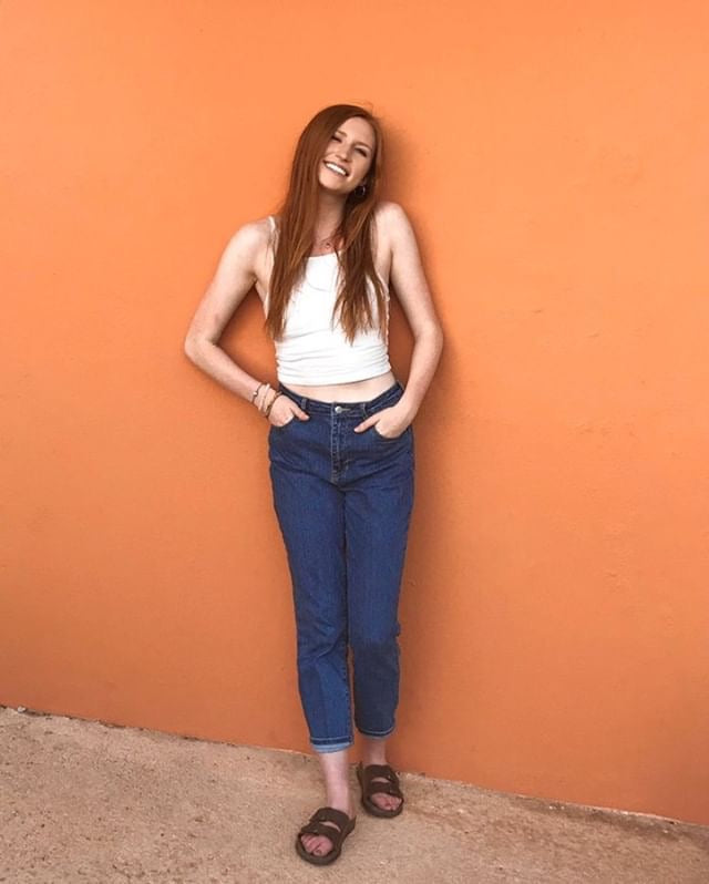 Woman wearing a resilience cultural bracelet with casual outfit against an orange background