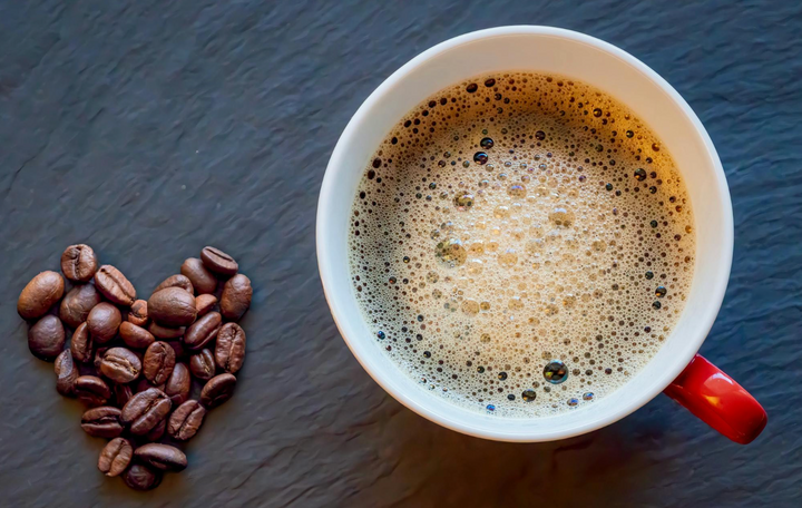 Pure Puerto Rican coffee in white mug with red handle and coffee beans