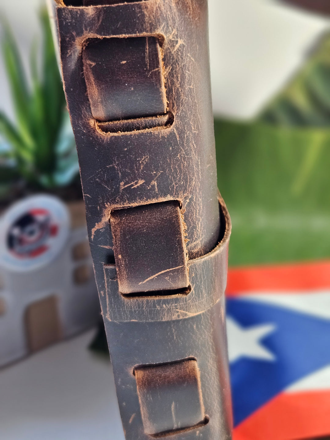 Close-up of rustic brown leather handbag featuring unique strap design and texture