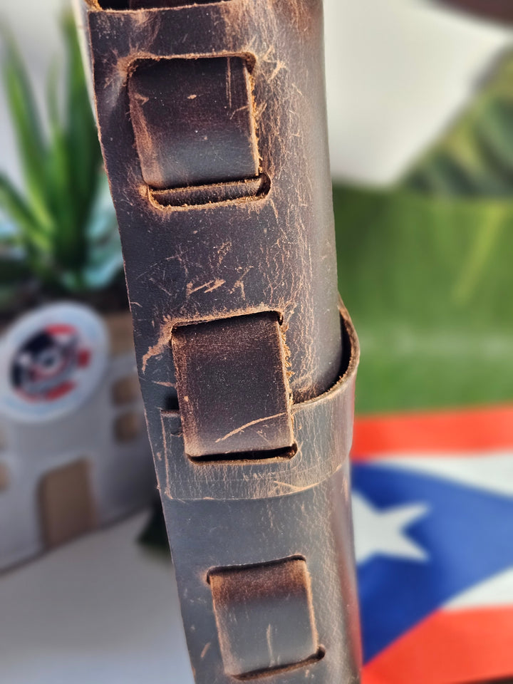 Close-up of rustic brown leather handbag featuring unique strap design and texture