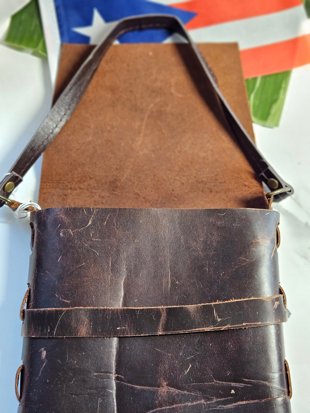 Rustic brown leather handbag with a unique design and adjustable strap for everyday use
