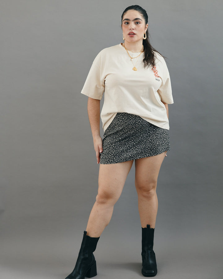 Valija Ay Bendito graphic T-shirt in cream color styled with a patterned mini skirt and black boots