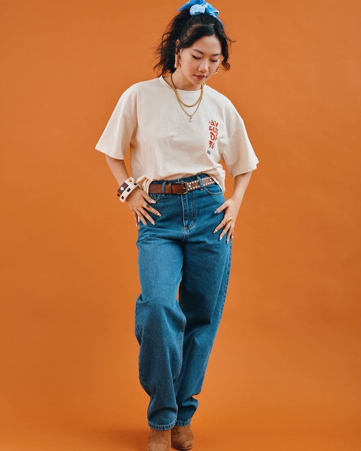 Valija Ay Bendito graphic T-shirt in cream with relaxed fit paired with high-waisted denim jeans