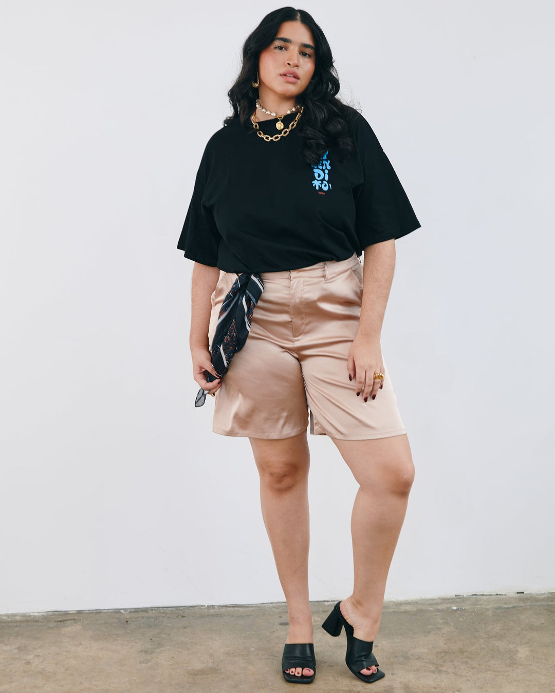 Valija Ay Bendito graphic T-shirt in black, styled with beige shorts and accessories for a casual look.